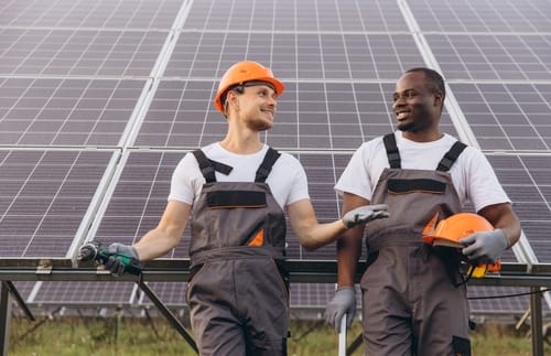 Two,Male,Workers,In,Uniforms,And,Helmets,,Smiling,And,Talking
